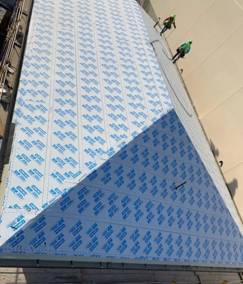 Professional roofers installing underlayment on a metal roof in Mercedes